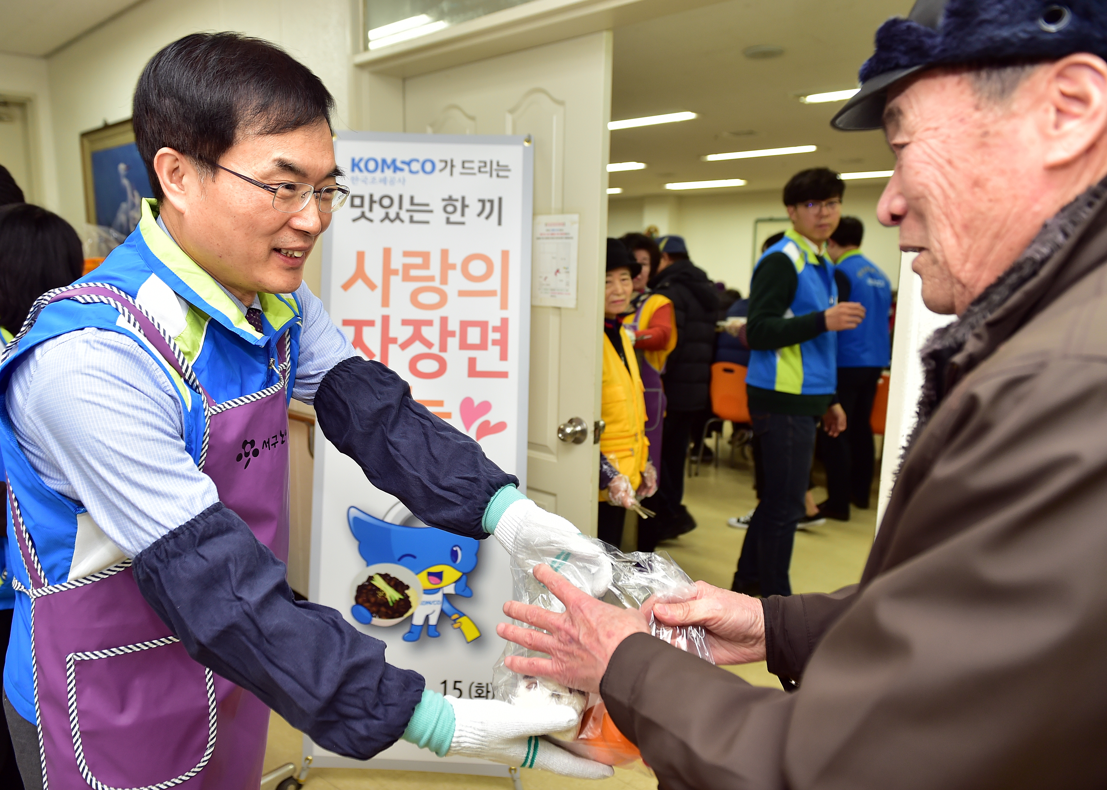 다과를 담은 간식 꾸러미를 전달하는 조용만 사장(좌)